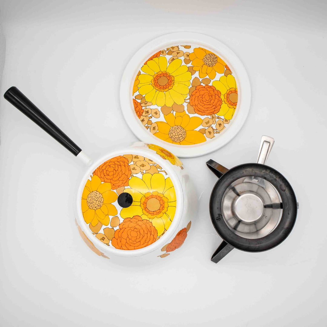 Fondue Set Emaille mit gelben und orangen Blumen, von oben in Einzelteilen fotografiert