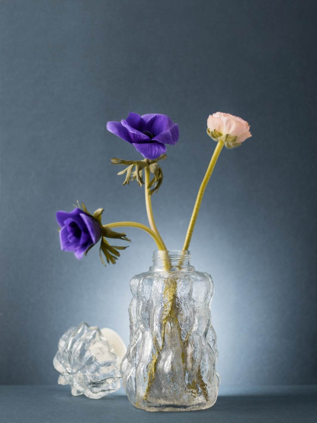 Tandlas, Eisglas Karaffe mit lila Blumen vor dunklem Hintergrund