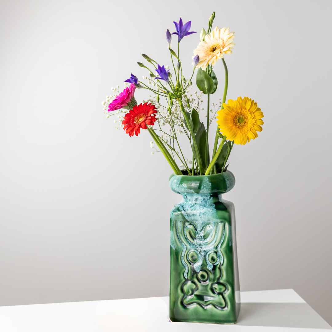Vase mit grüner Laufglasur und Blumen