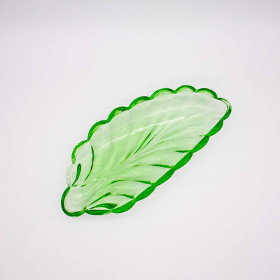 Grüne Schale aus Glas in Blattform, von oben fotografiert