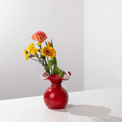 Rote Glasvase mit Blumen